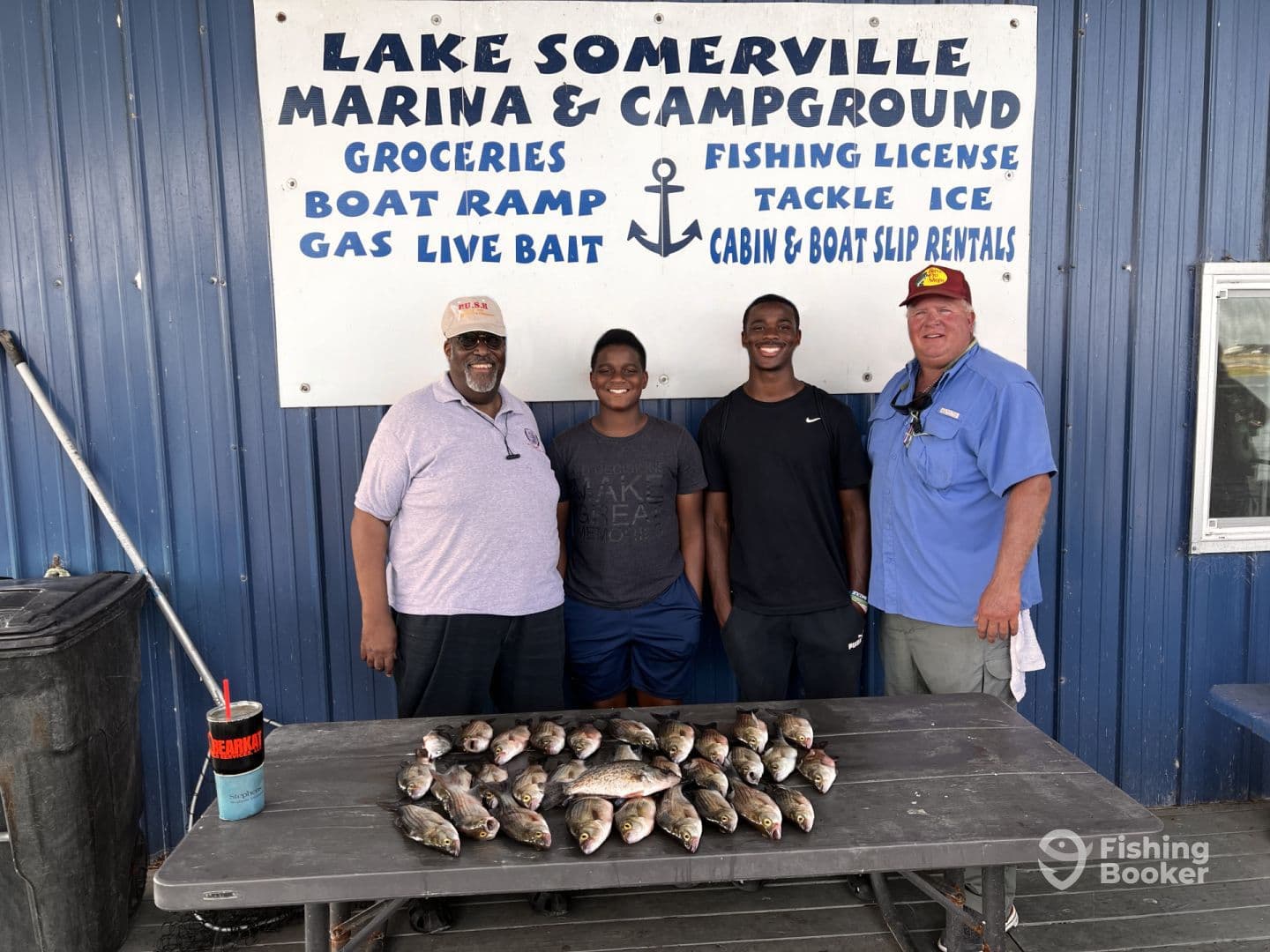 A group of anglers proudly displaying their catch of Crappie and Bass at Lake Somerville Marina, showcasing a successful fishing trip.