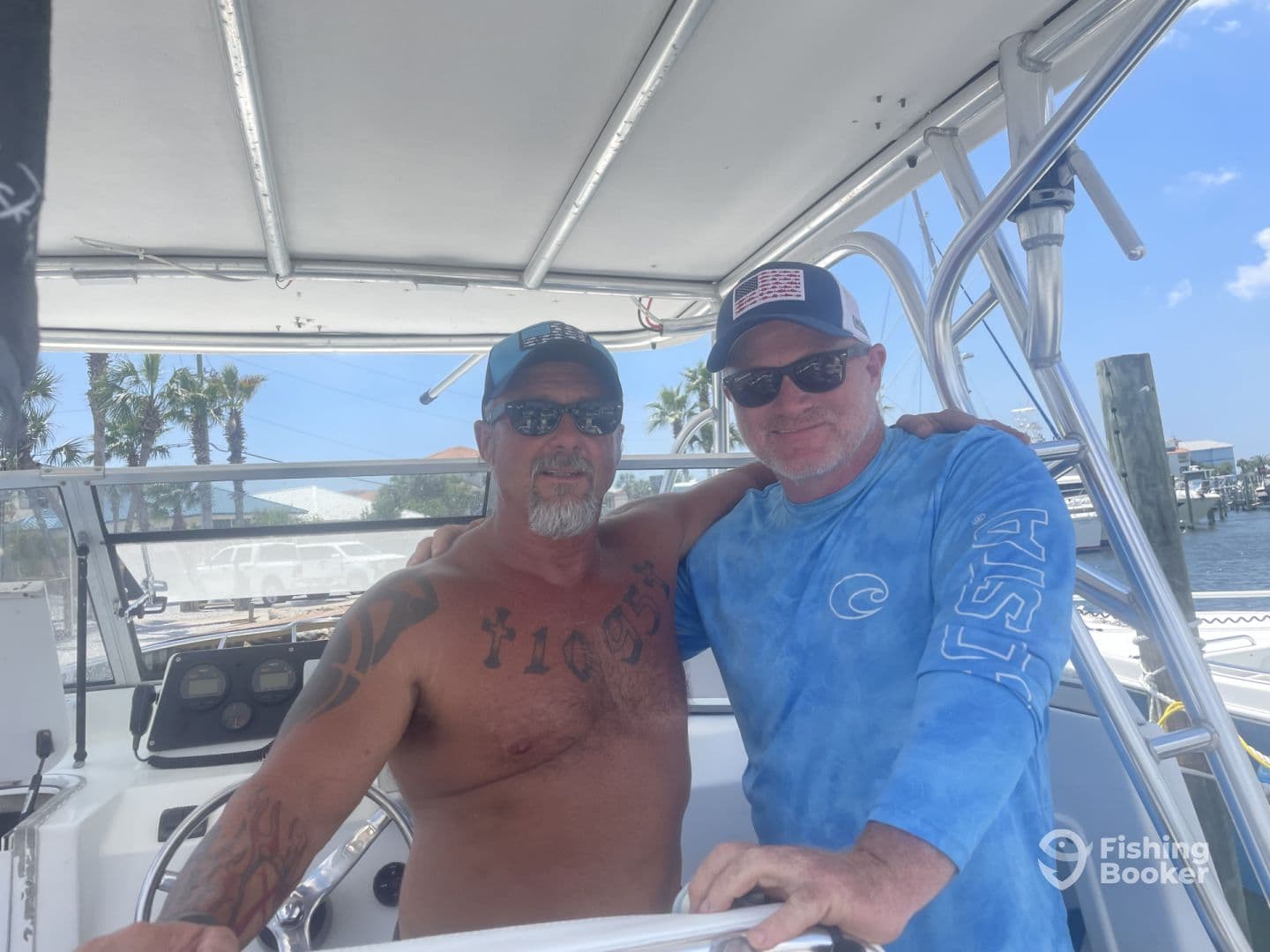 Two anglers posing inside the boat, showcasing a sunny day at the marina with palm trees in the background.