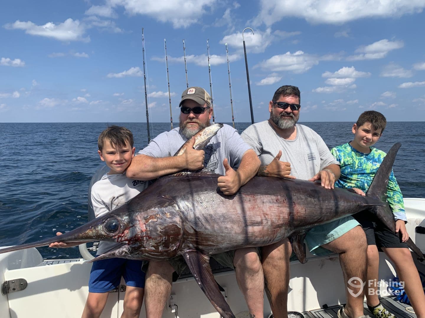 A group of anglers proudly displaying a large Swordfish on a fishing charter, enjoying a successful day on the open water.