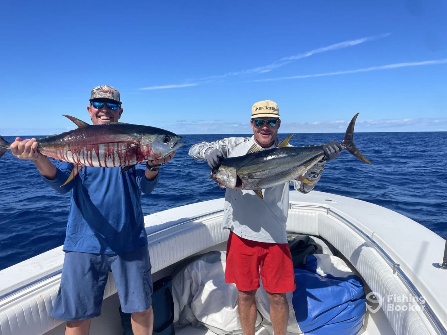 Two anglers proudly displaying their catches of Yellowfin Tuna while fishing in open waters.