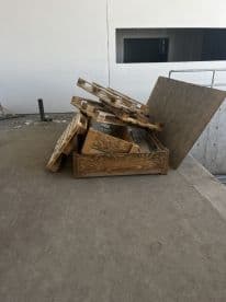An unclear image showing a pile of wooden pallets and debris in an unfinished area, lacking any fishing-related elements.