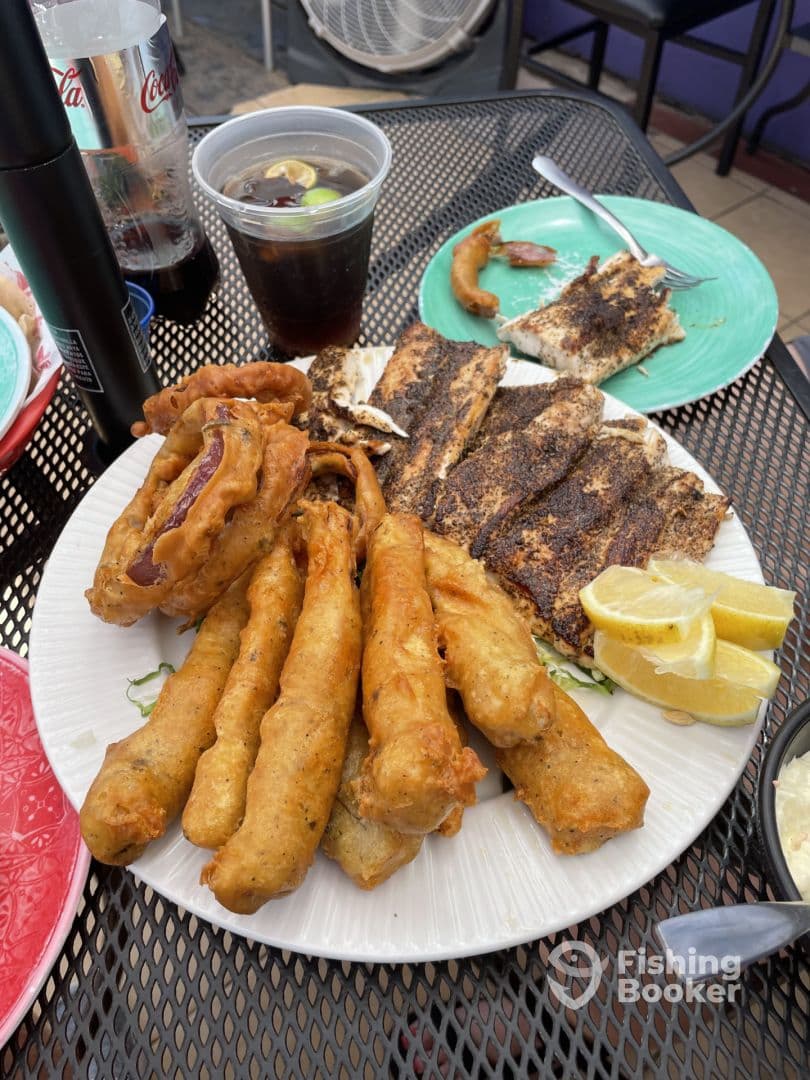A plate of fried fish and sides served at a dining table, showcasing a variety of dishes but lacking a clear fishing context.