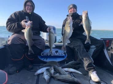 Two anglers proudly displaying their catch of Walleye while fishing on a boat, showcasing a successful day on the water.
