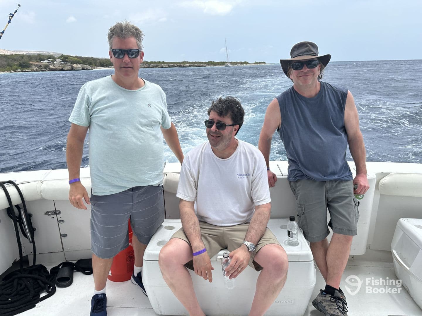 Three adult anglers relaxing on the boat's seating area, enjoying a day out on the water.