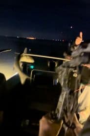 Angler reeling in a fish at night, showcasing the excitement of night fishing on the water.