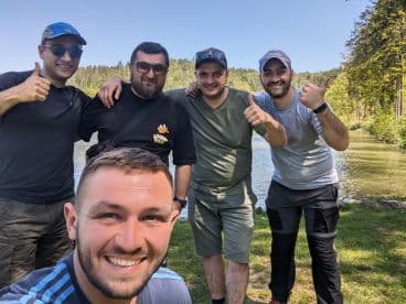 Group of friends enjoying a day by the water, smiling and posing for a selfie.