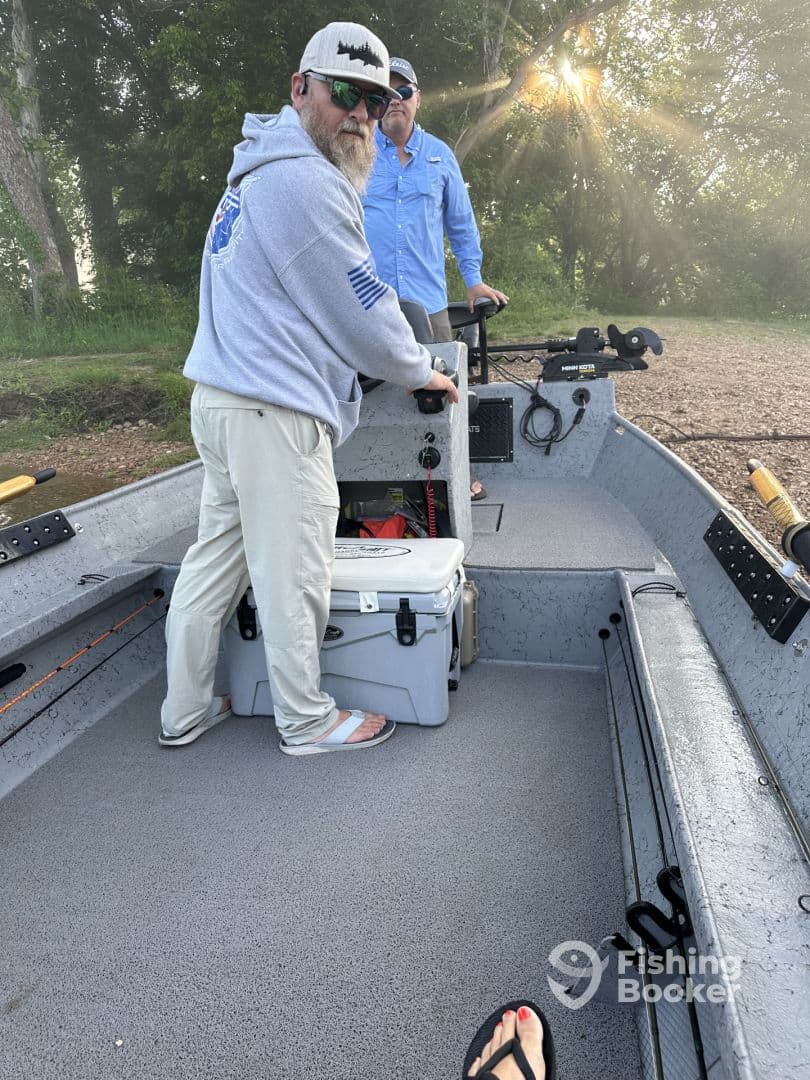 Two anglers preparing for a fishing trip inside a well-equipped boat, showcasing the interior layout and fishing gear.
