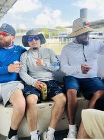 Group of anglers relaxing inside the boat, showcasing a casual fishing atmosphere before heading out.
