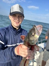 A young angler proudly displaying a freshly caught fish while enjoying a day on the water.