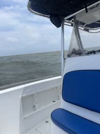 Interior view of a fishing boat showcasing comfortable seating and a clear view of the water, ideal for a day of fishing.