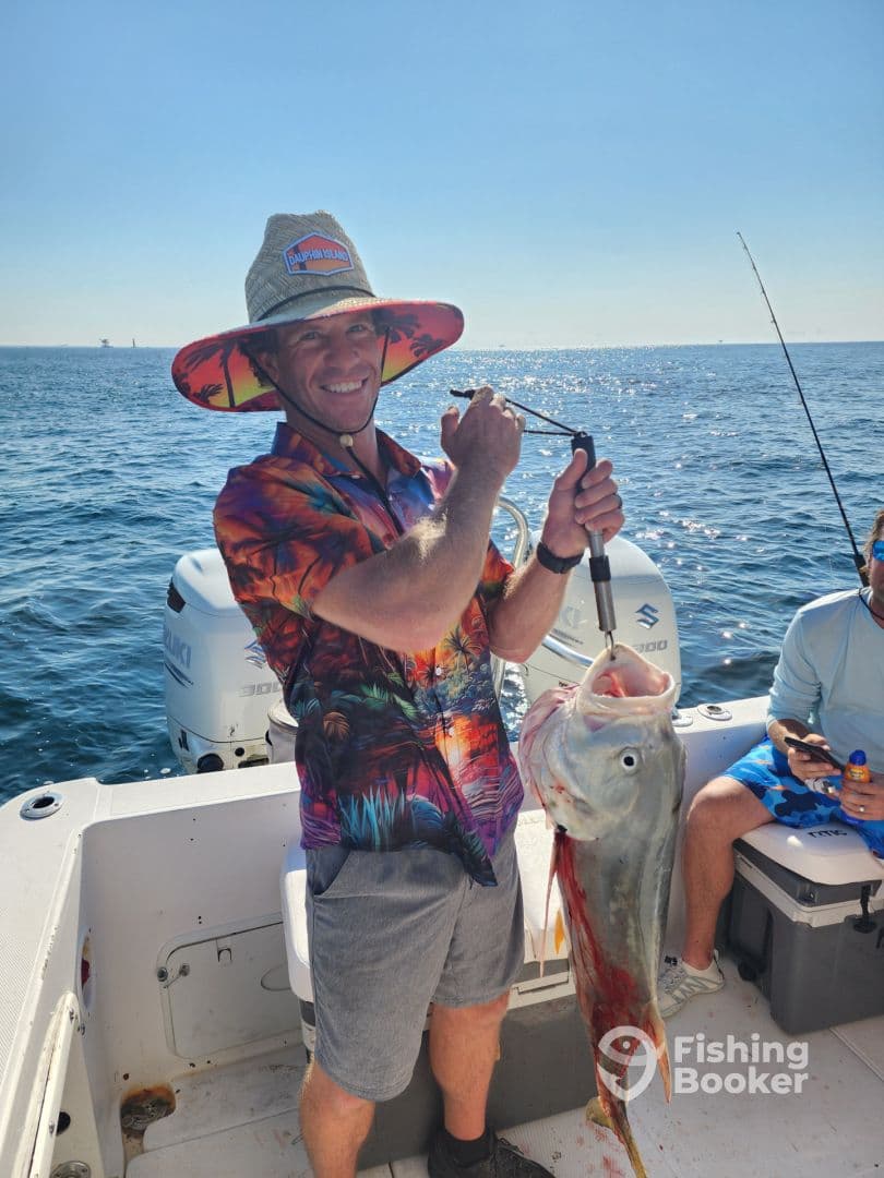 An angler proudly displaying a large fish while fishing on a sunny day, showcasing the excitement of a successful catch.