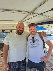 Two anglers posing together inside the boat, showcasing a relaxed atmosphere after a fishing trip.