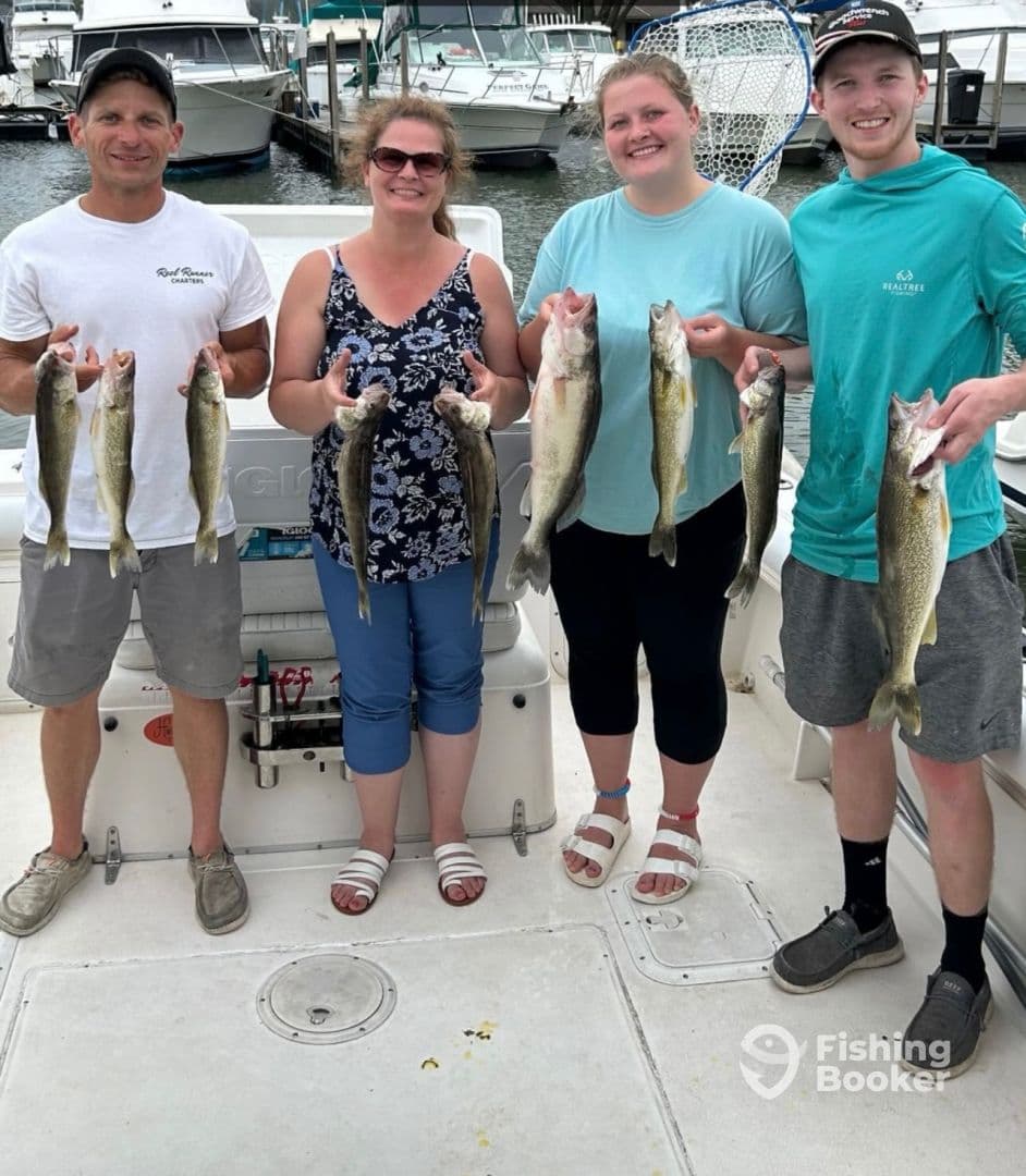 A group of four anglers proudly displaying their catch of Walleye on a fishing charter, showcasing a successful day on the water.