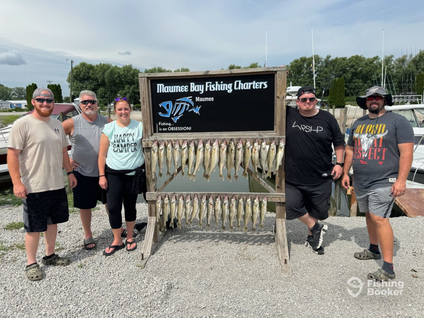A group of anglers proudly posing with their catch of Walleye displayed on a board at Maumee Bay Fishing Charters, showcasing a successful day on the water.
