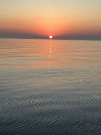 A serene sunset over calm waters, capturing the tranquil beauty of the fishing environment.