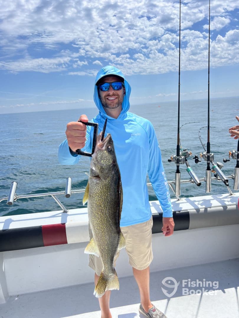 Angler proudly displaying a large Walleye while fishing on a sunny day, showcasing a successful catch on the water.