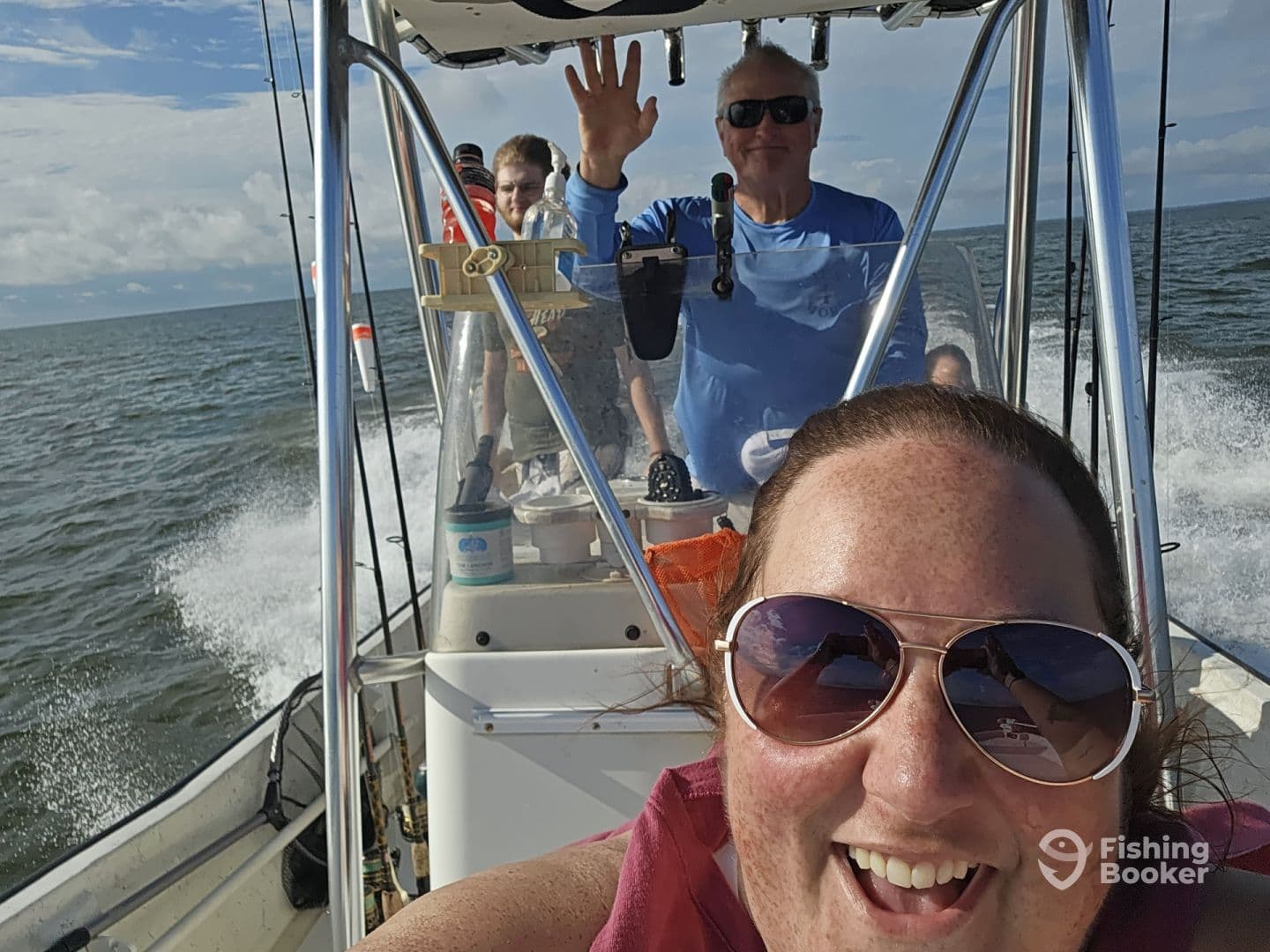 Group enjoying a day on the water, with smiles and a scenic backdrop while navigating in a center console boat.