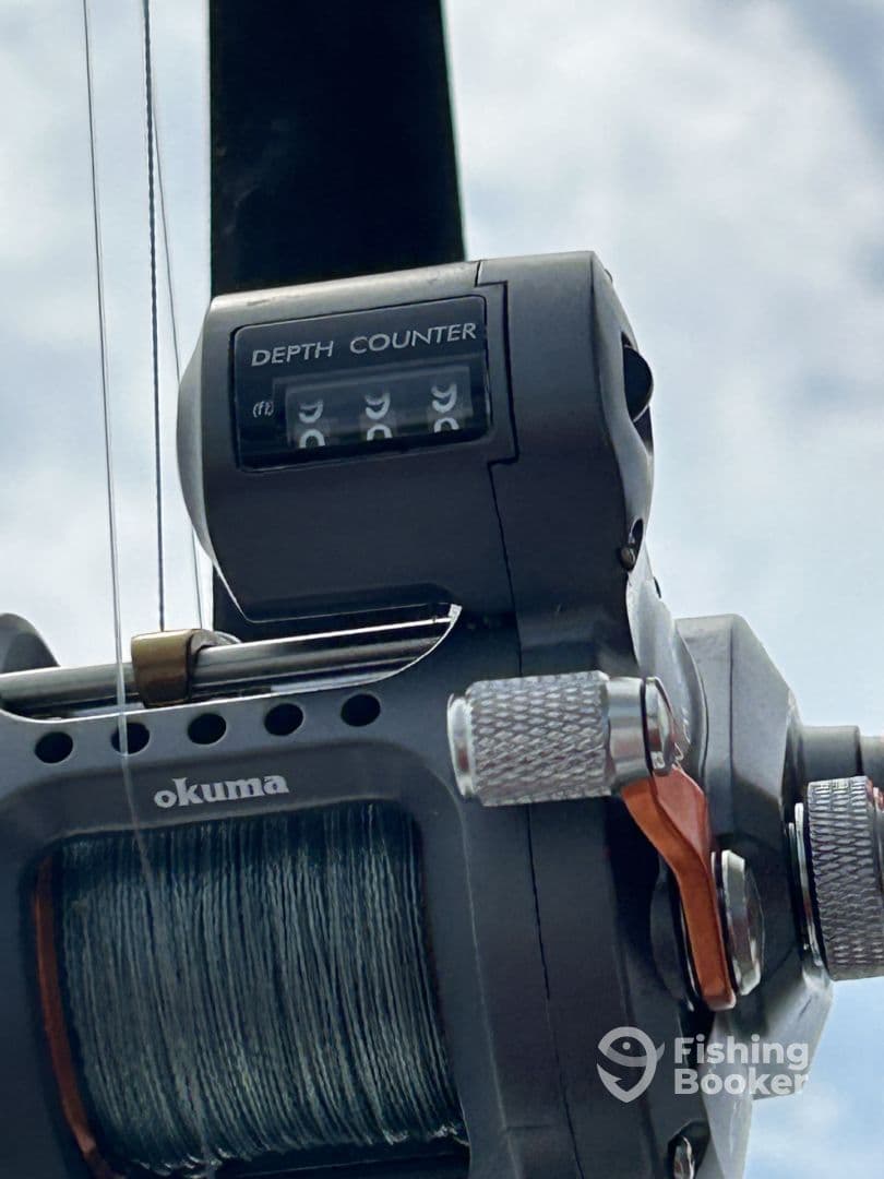 Close-up of a fishing reel featuring a depth counter, showcasing essential fishing equipment for deep-sea angling.