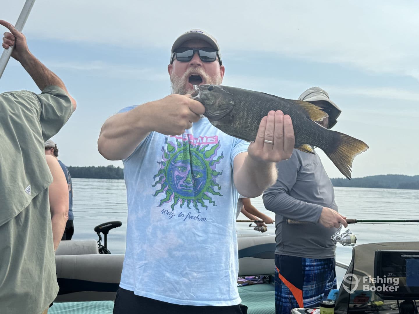 An angler proudly displaying a large Largemouth Bass while fishing on a serene lake, surrounded by fellow fishermen.