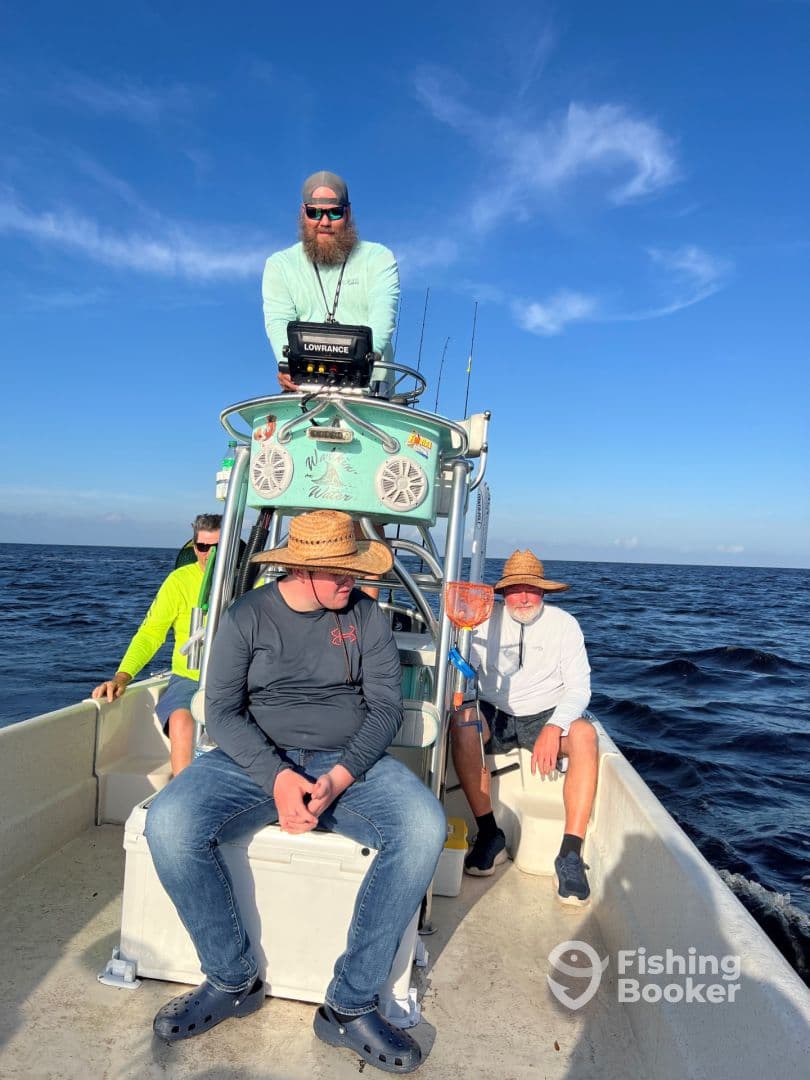 Group of anglers relaxing inside a center console boat, enjoying a sunny day on the water.