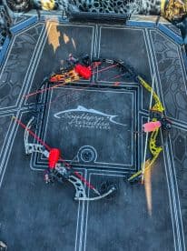 An overhead view of several bows arranged on the deck of a charter boat, showcasing the unique fishing equipment used for bowfishing.