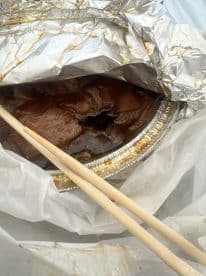 An unclear image showing a container of food with chopsticks, lacking any visible fish or fishing context.