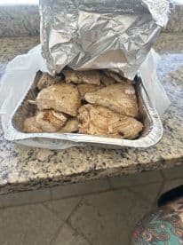 A tray of freshly cooked fish fillets, likely from a recent fishing trip, displayed on a kitchen countertop.