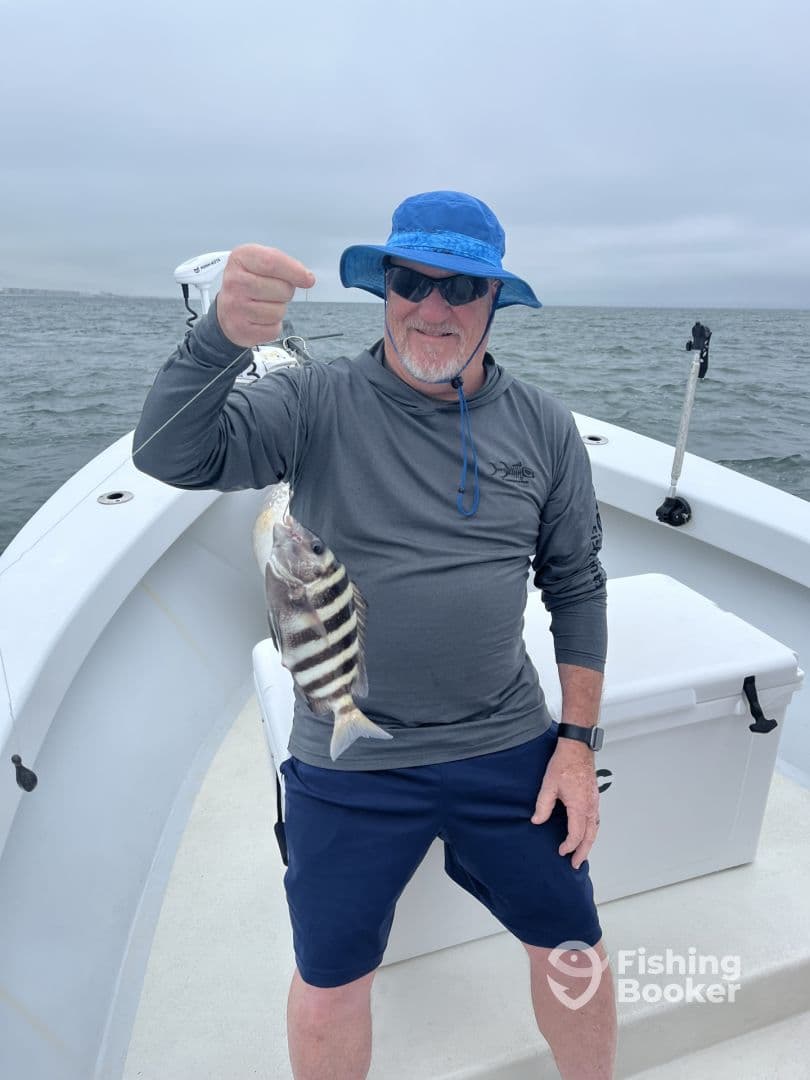 An angler proudly displaying a striped fish while fishing from a boat, showcasing a successful day on the water.