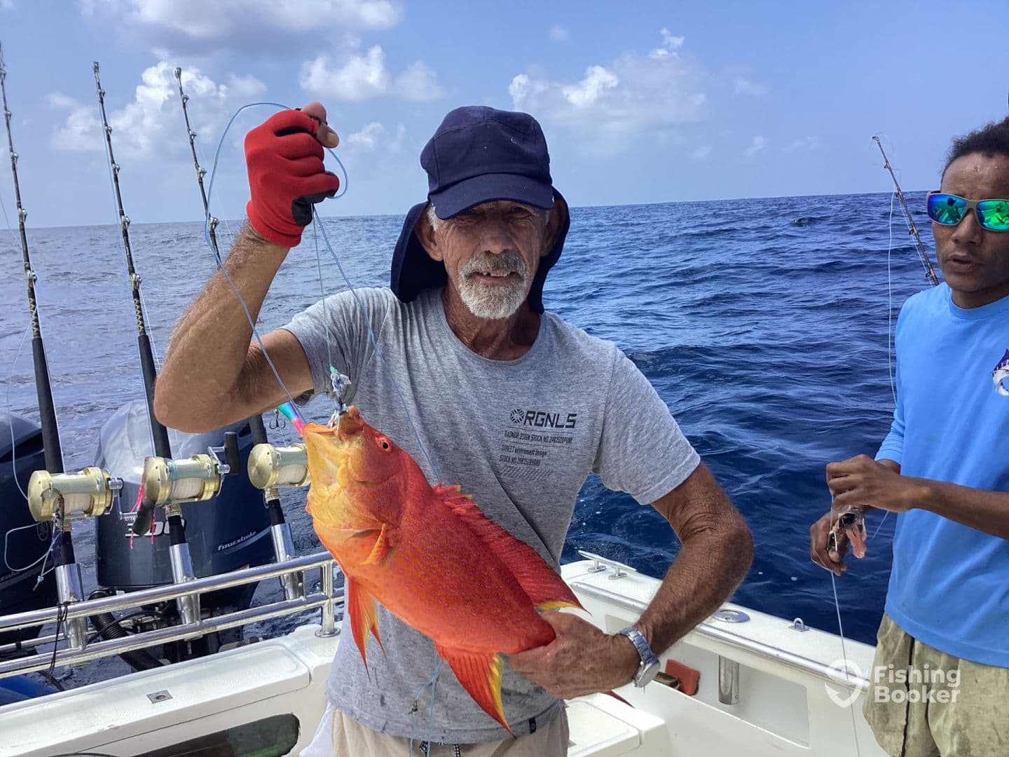 An angler proudly displays a vibrant Red Snapper while fishing offshore, showcasing the excitement of a successful catch.