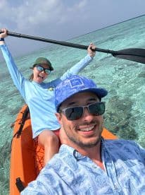 A joyful couple kayaking in clear waters, showcasing a fun day on the water.