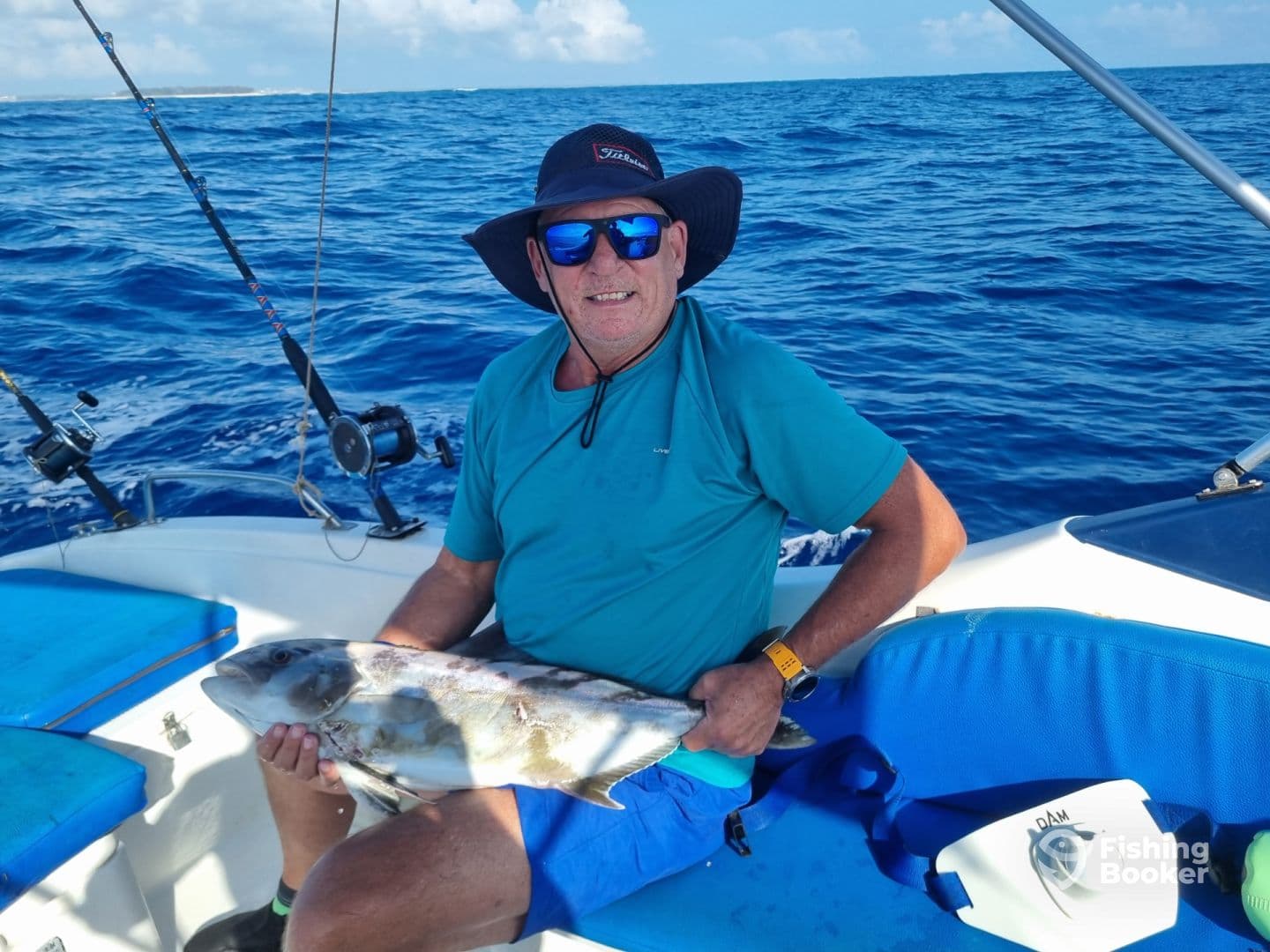 An angler proudly displaying a large fish while seated on a boat in open waters, showcasing a successful fishing trip.