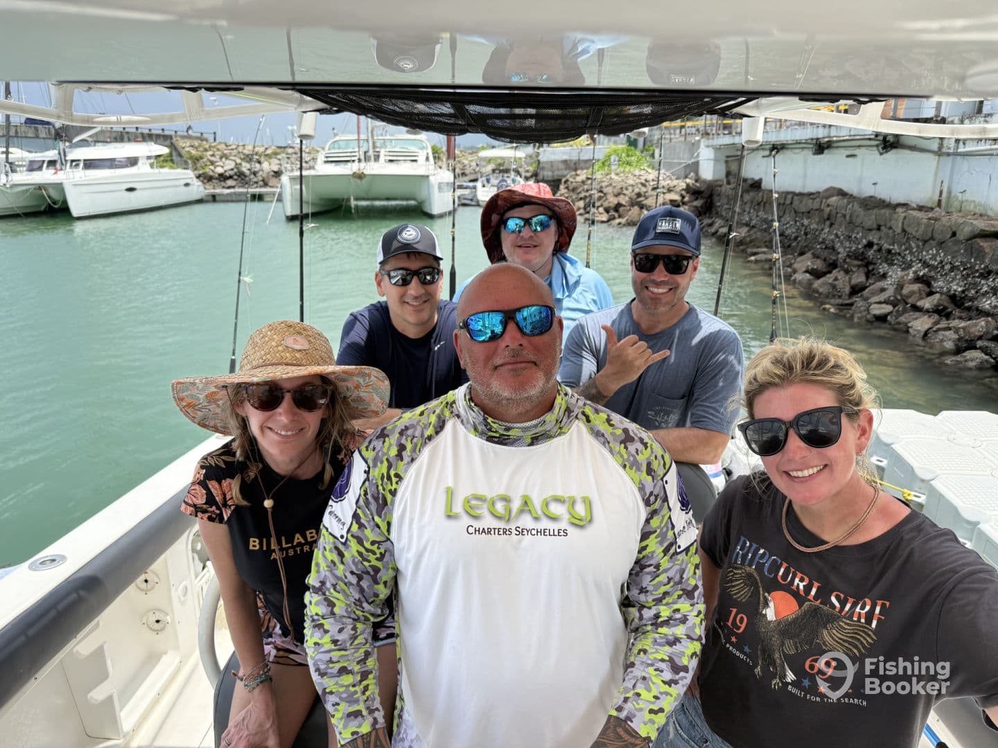 Group of anglers enjoying a moment on the boat before heading out for a fishing adventure, showcasing a relaxed atmosphere.