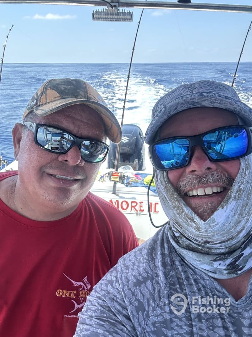 Two anglers enjoying a day on the water, showcasing camaraderie aboard a fishing boat.