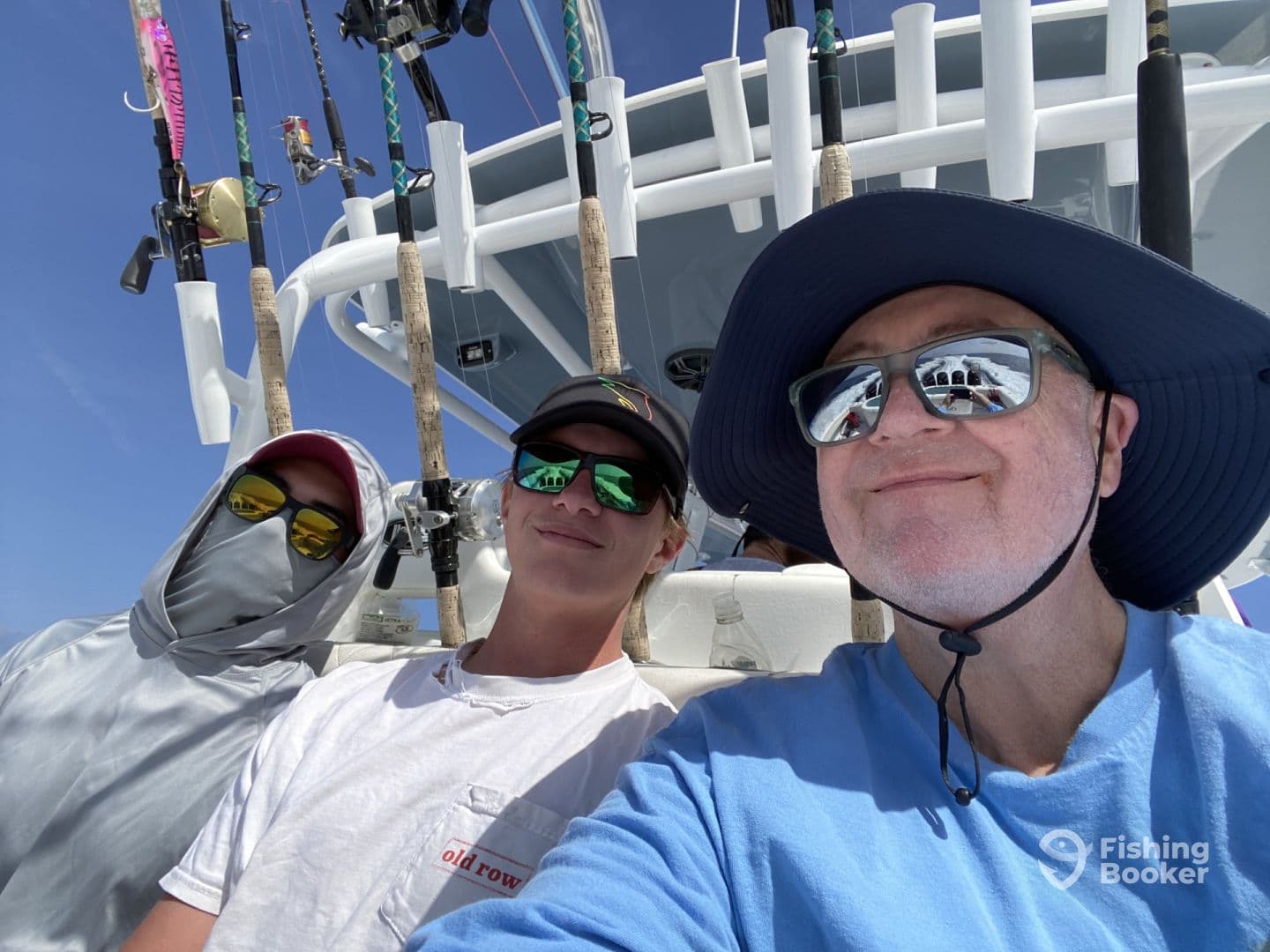 Three anglers enjoying a day on a fishing boat, showcasing the comfortable seating and fishing gear setup.