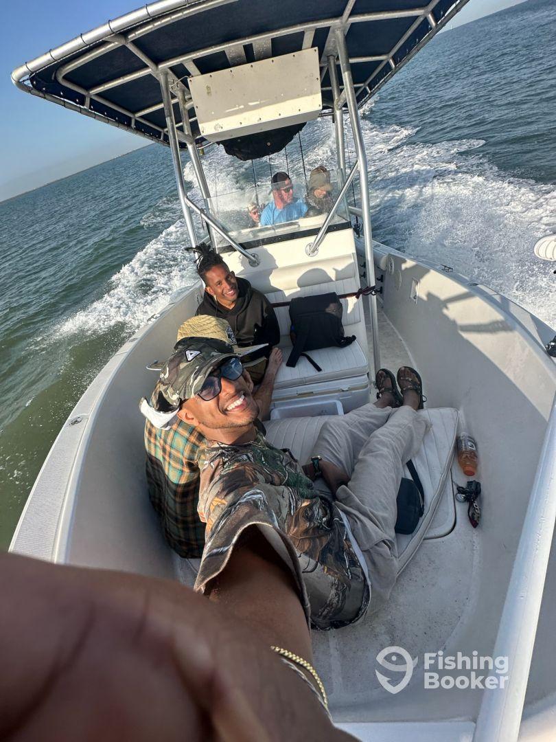Group of friends enjoying a day on a fishing boat, capturing a fun moment while cruising on the water.
