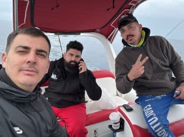 Three anglers relaxing inside the boat, showcasing a comfortable seating area while preparing for a fishing trip.
