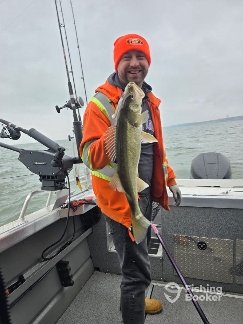 Angler proudly displaying a Walleye aboard a fishing boat, showcasing a successful catch during a cloudy day on the water.