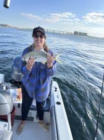 A proud angler holding a beautiful fish while enjoying a day on the water, showcasing the excitement of a successful fishing trip.