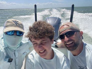 A family enjoying a sunny day on a boat, capturing a moment while cruising on the water.