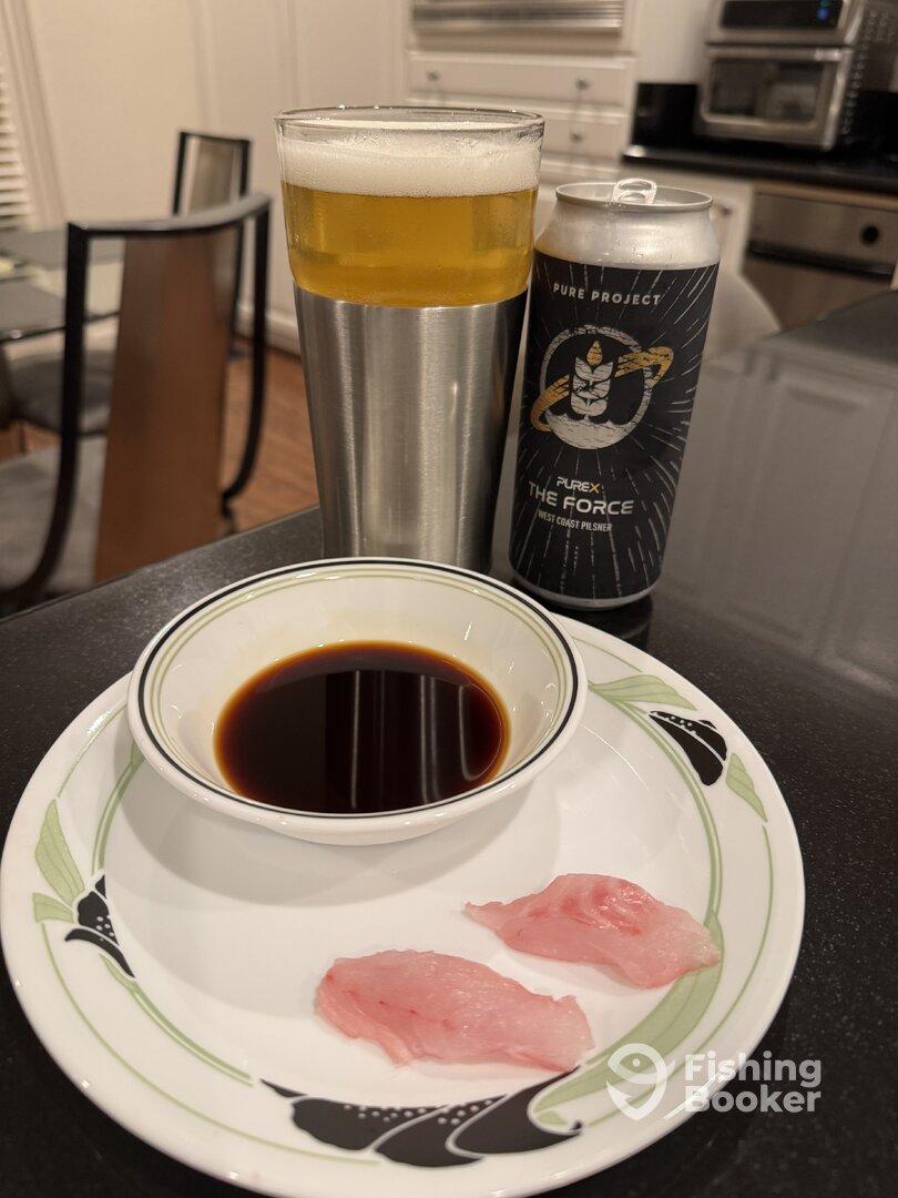 A plate with sashimi, soy sauce, and a beer can, suggesting a casual dining experience.