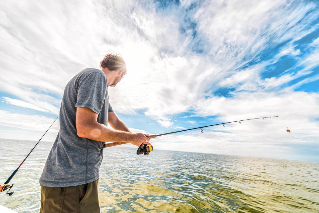 A man fishing in the shallow clear waters of the Everglades Park