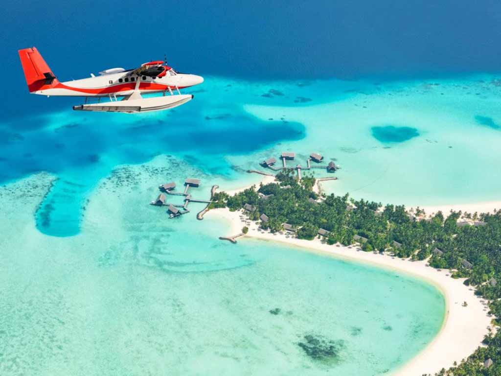 An aerial view of a seaplane flying over one of the thousands of islands in the Maldives on a clear day