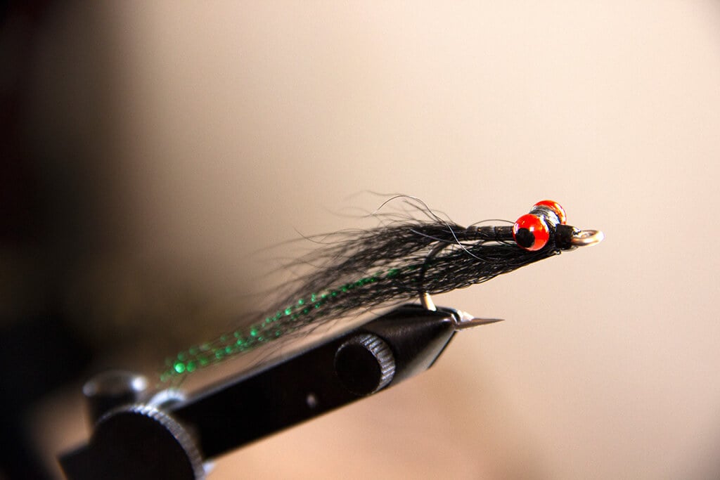 A Clouser Minnow on a fly tying vise