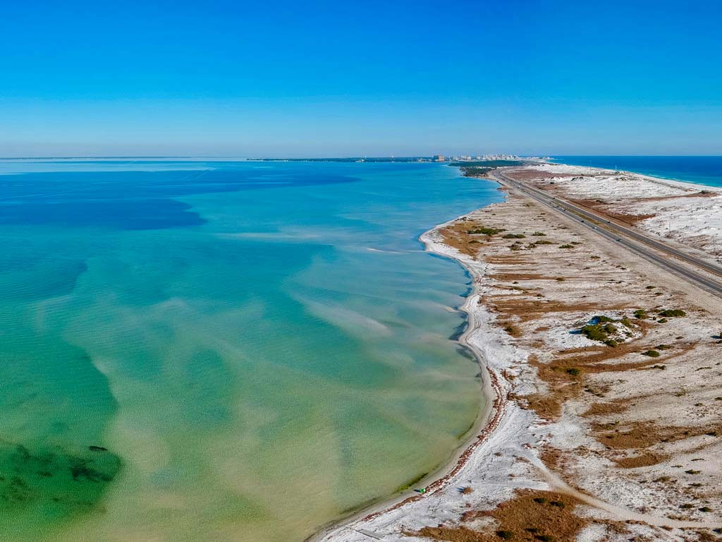 An aerial photo showing a road and waters between Destin and Okaloosa Island