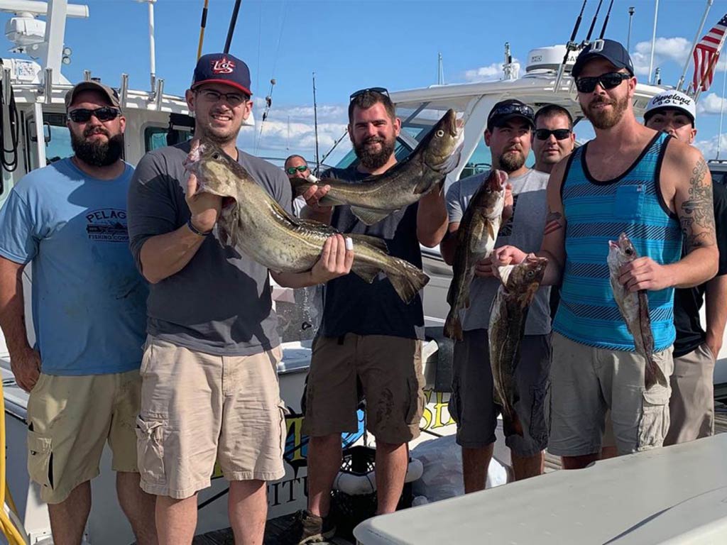 A group of anglers at the dock holding their catch of Haddock after a successful Cape Cod fishing adventure
