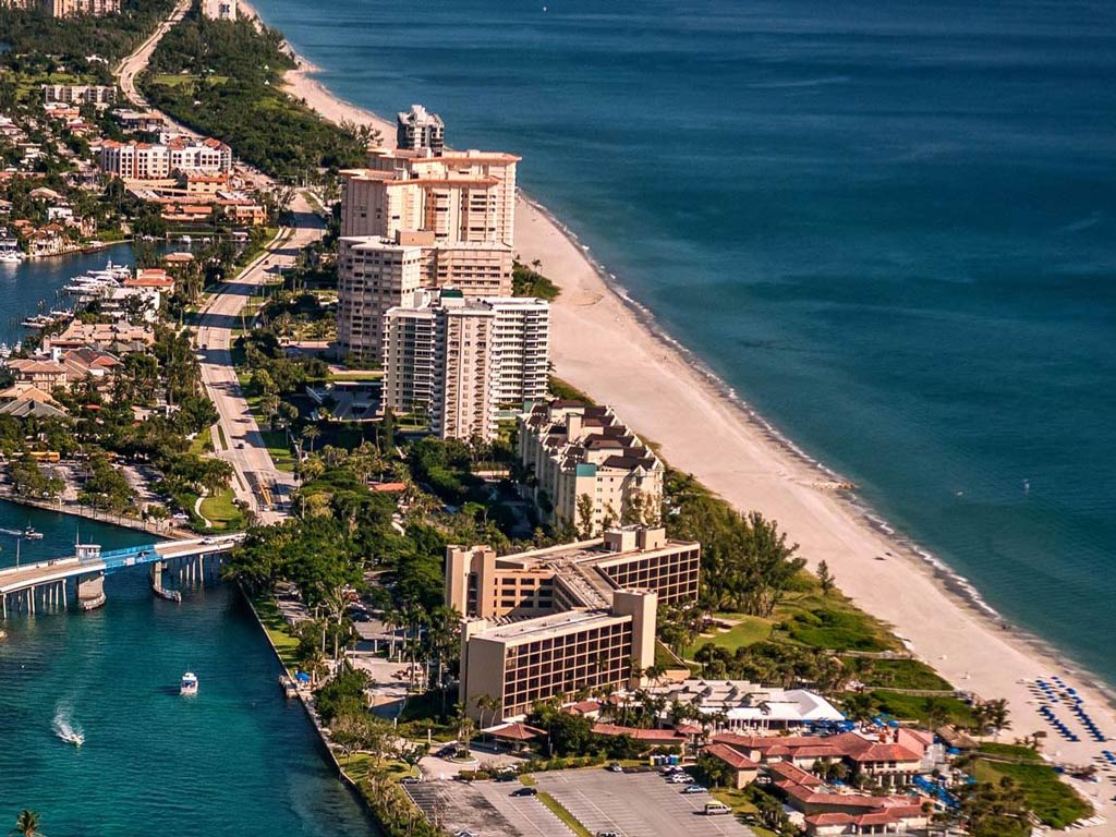 An aerial shot of Boca Raton and Lake Boca Raton, with the Atlantic Ocean on the right of the image, and high rise buildings and greenery separating it from the lake in the middle