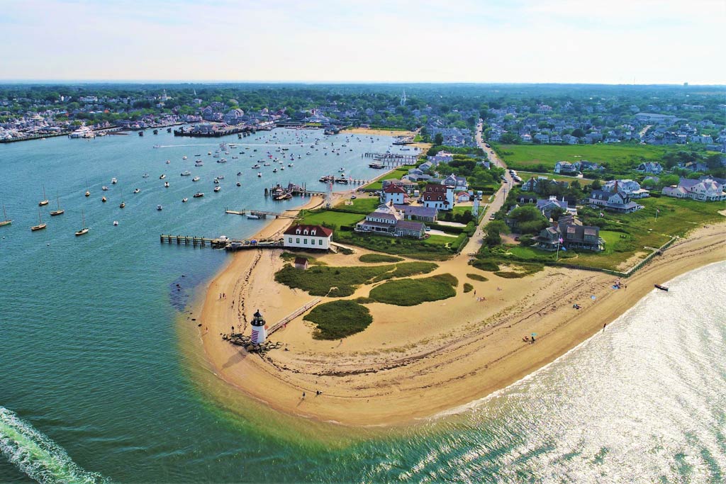 A scenic aerial photo of Nantucket Island, its beaches, and various boats in the water