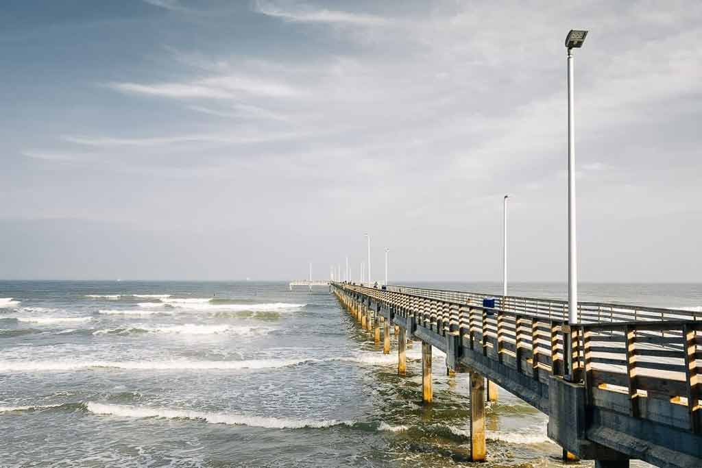 A pier in Corpus Christi with small waves in the surrounding water