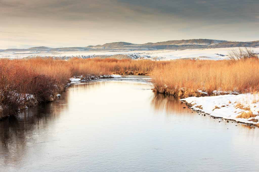 Gallatin River near Bozeman, Montana with snow on the ground on a grey winter day