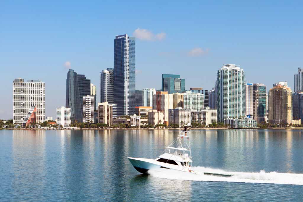 Miami cityscape from the water, with a boat passing by